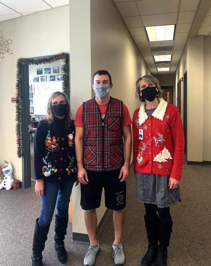 Office workers Mary Hale, Stephanie Timm, and Gym teacher Ryan Whitman pose for a picture in their holiday attire.