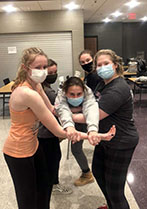 Junior Natalie Spinsby, and seniors Alice Conroy, Sophia Andrews, and Sage McVay hold junior Ashlyn Steen during a musical theatre rehearsal.