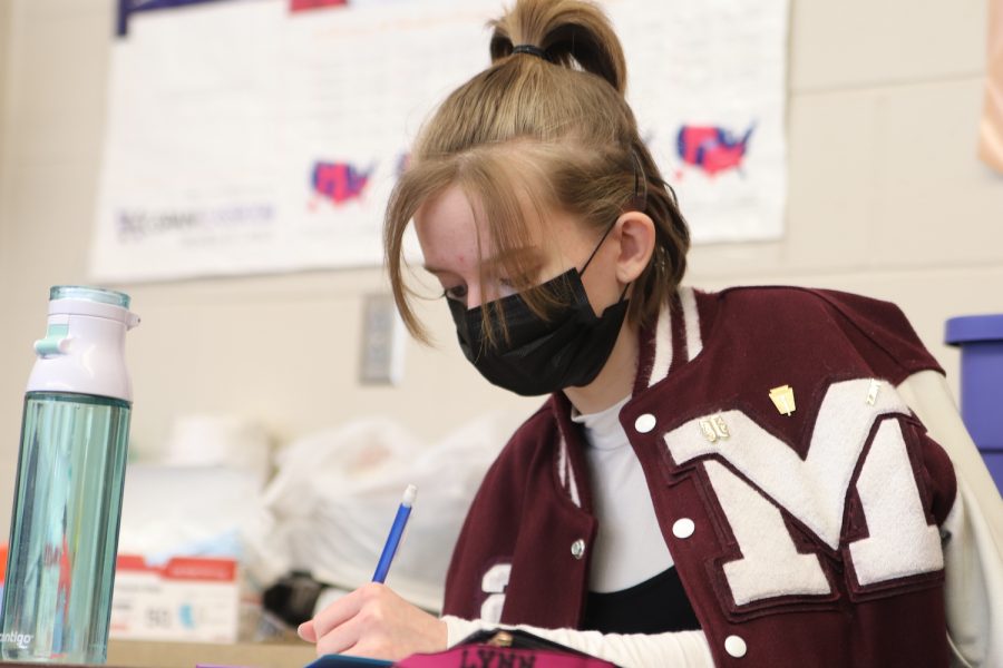 Diligently taking notes, senior Kaylynn Burgin listens to Mr. Timm talk in Political Science Feb. 3. The class was learning about the legislative branch of government.