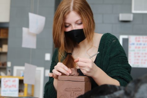 Molding the clay into a knob for her box, sophomore Laila Moellering puts the finishing touches on her project in Ceramics Feb. 3. Moellering etched designs onto the faces of her box. One face depicted a mushroom and Moelllering planned on making the knob on top of her box a mushroom as well.