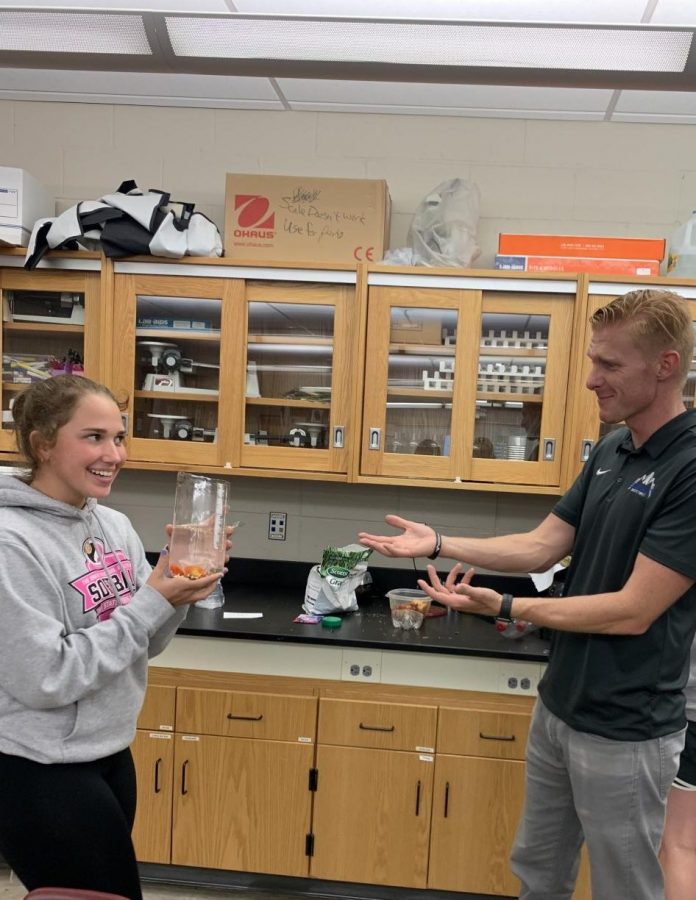Sophomore Kenna Rollinger presents her biogoly project to science and math teacher Derek Roberts who commends her work. 
