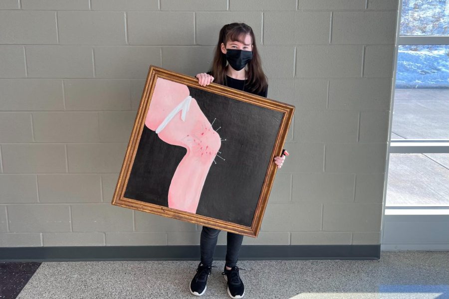 Senior Jessica Belding holds up one of her paintings.