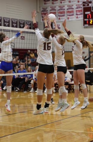 Seniors Emma Meester, Parker Whitham, and Madeleine Miller jump up to block the other teams return. 