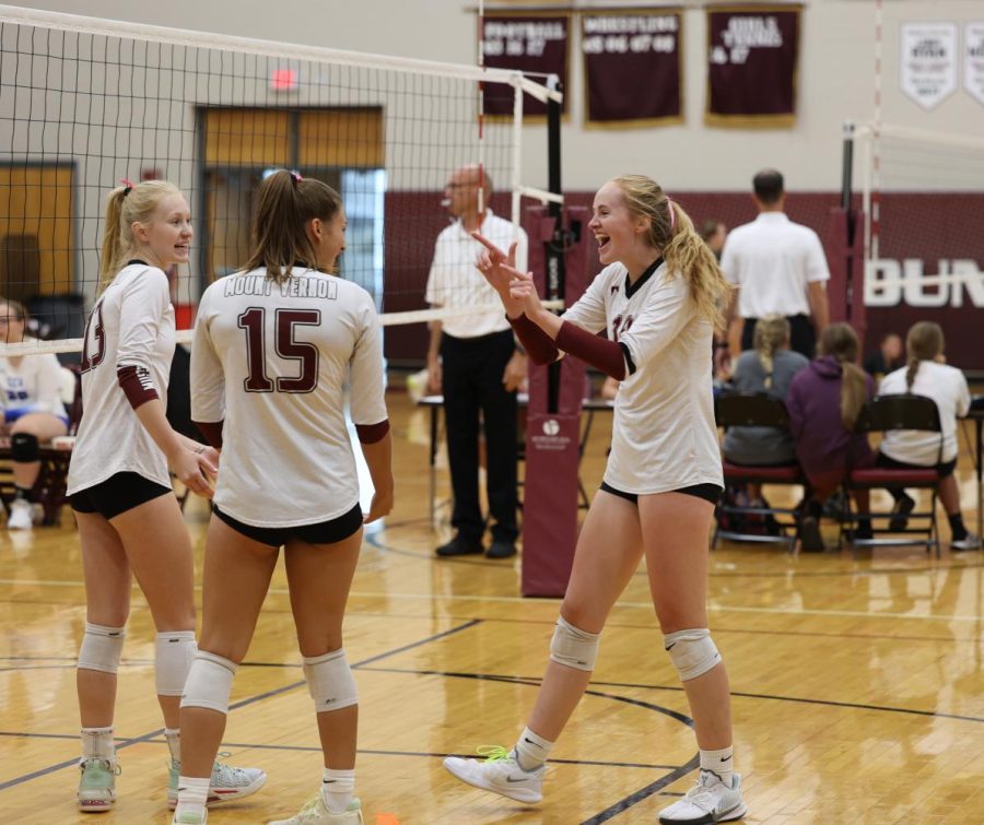 Senior Madeleine Miller congratulates her teammates, Parker Whitham and Emma Meester, after a successful play. 