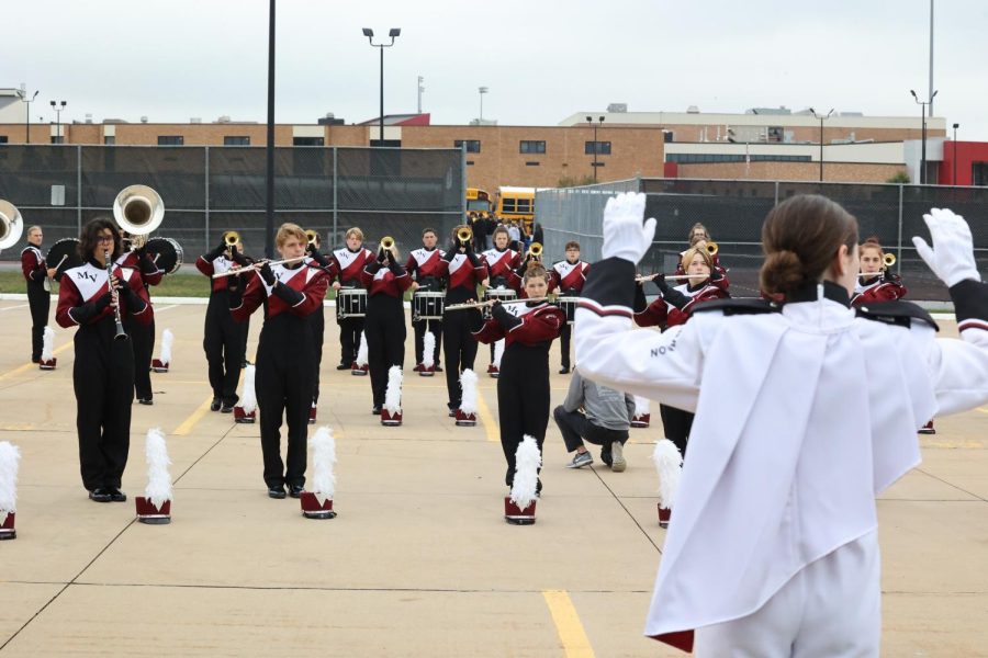 Sophomore Clare Nydegger conducts the marching band during rehearsal.