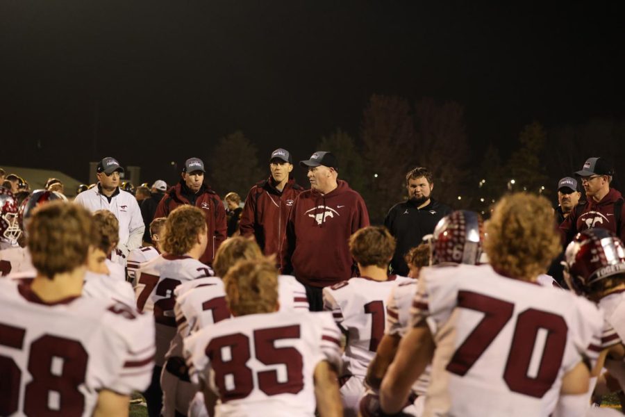 Head Coach Lance Pedersen conversing with his players after winning over the Vinton-Shelsberg Vikings with a final score of 55-6.