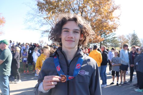 Grady Olberding smiles with his 14th place medal for class 3A boys at state.