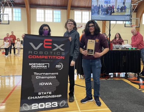 Team 85A Chassis Kickers members hold up their VEX Robotics State Excellence banner and trophy.  The  team qualifies for Middle Schoool Vex World Robotics Championships held in April in Dallas.