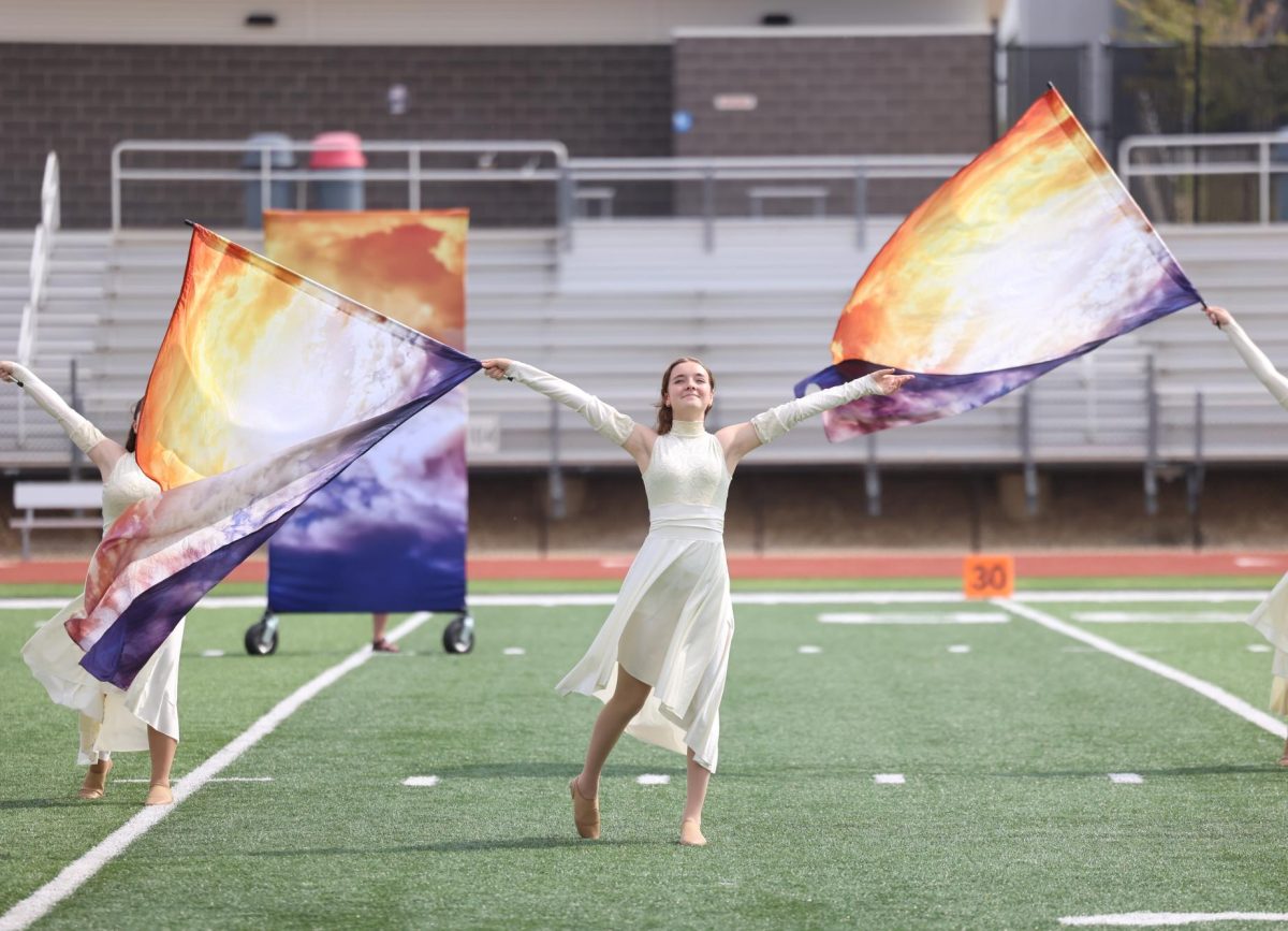 Junior Brandy Hills spreads her arms during the color guard performance.