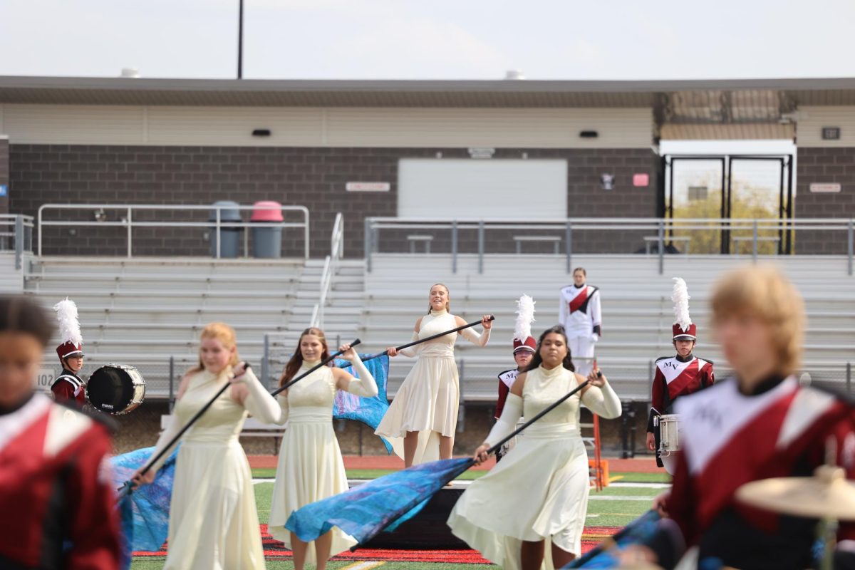 Junior Renee Vig stands above the color guard during their performance on Sept. 23. 