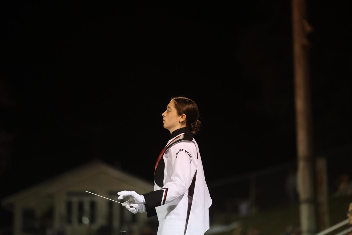 Junior Clare Nydegger prepares to start conducting the band during their football halftime performance on Sept. 15. 