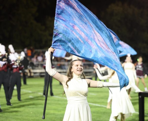 Sophomore Emily Giel joyously executes her part in the color guard performance. 