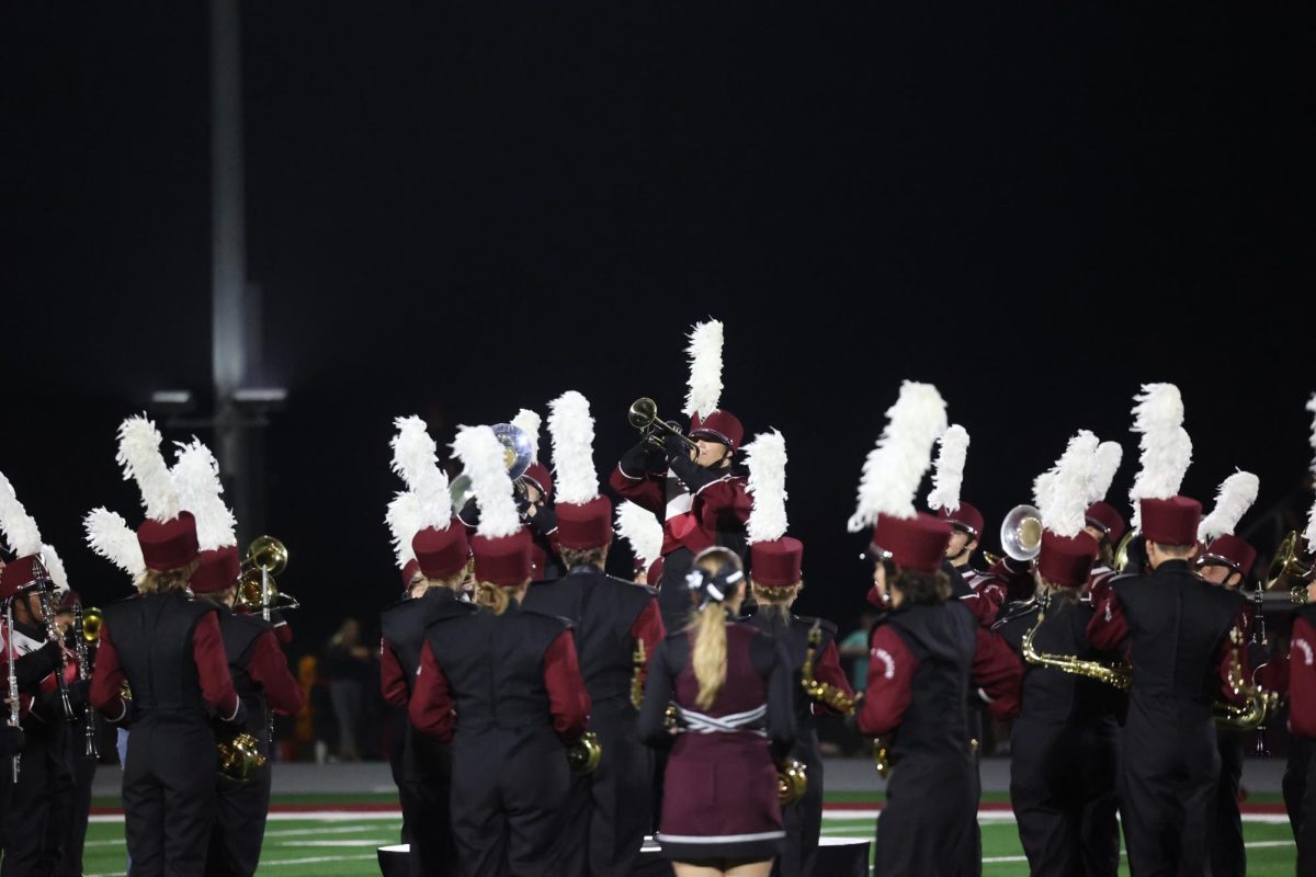 The Marching Mustangs surround soloists  Junior Penelope Vig and Senior Uwen Boettcher as they perform during the bands homecoming halftime show. 