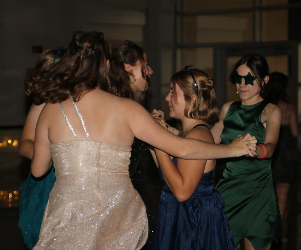 Sophomores Lydia Marshal, Katherine Whitehead, Mya Stoner, and Cora Smith dance around Mae Krapfl during a Taylor Swift song at the homecoming dance.