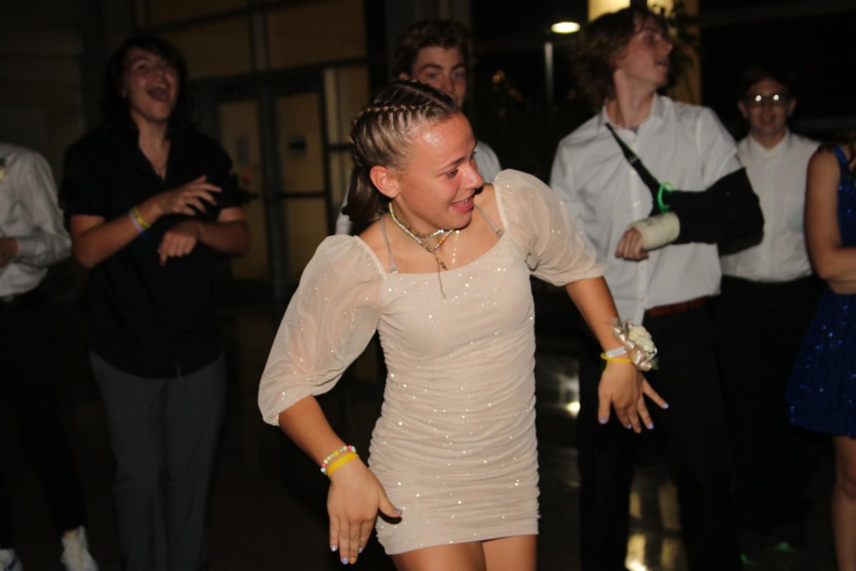 Junior Skylar Rodmen breaks it down while her classmates cheer during the homecoming dance.