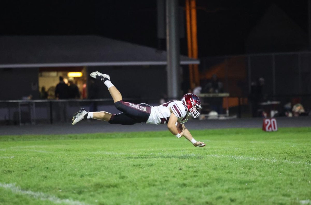 In mid-air, sophomore Jase Jaspers(24) dives for the extra yard.