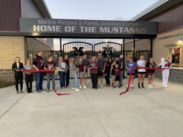 Alumni and Seniors representing football, marching band, and cheerleading take part in the ribbon cutting ceremony for the new Martha Parsons and Family Activity Center.