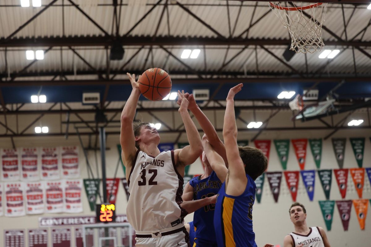 Junior Joe Briesemeister takes on two defenders as he goes up for a layup. 