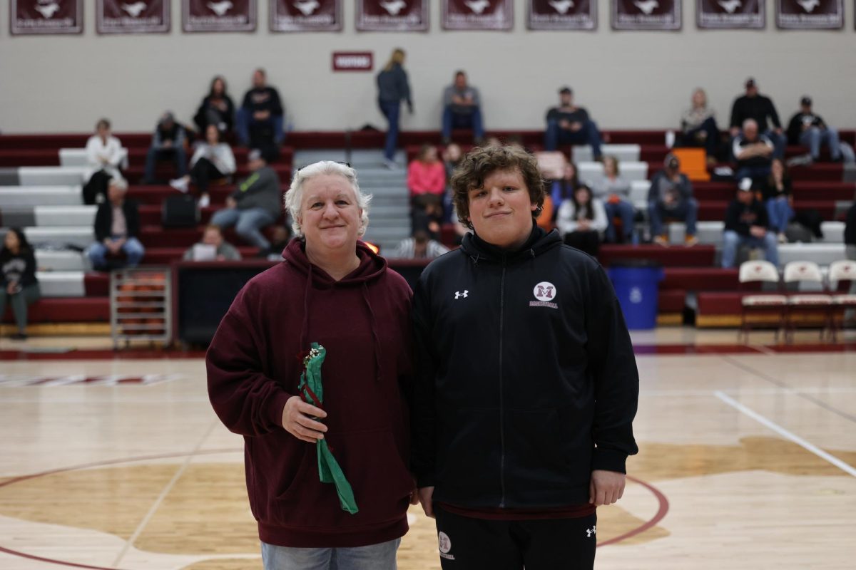 Jacob Rowell with his parent on senior night. 