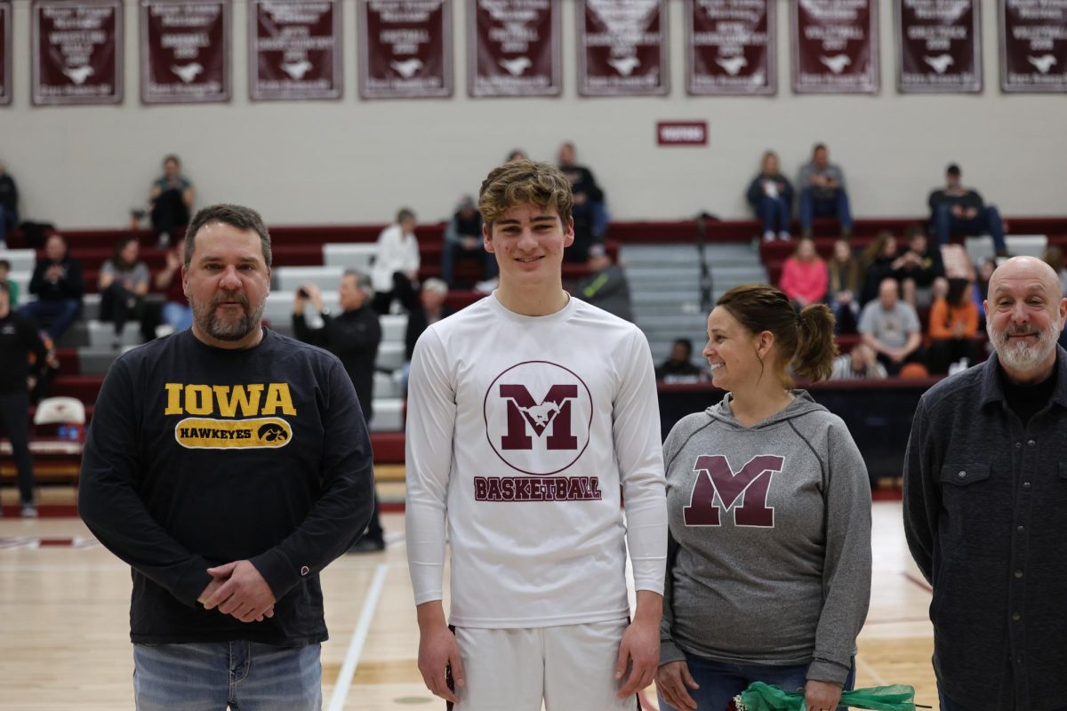 Oliver Hinrichs with his parents on senior night. 