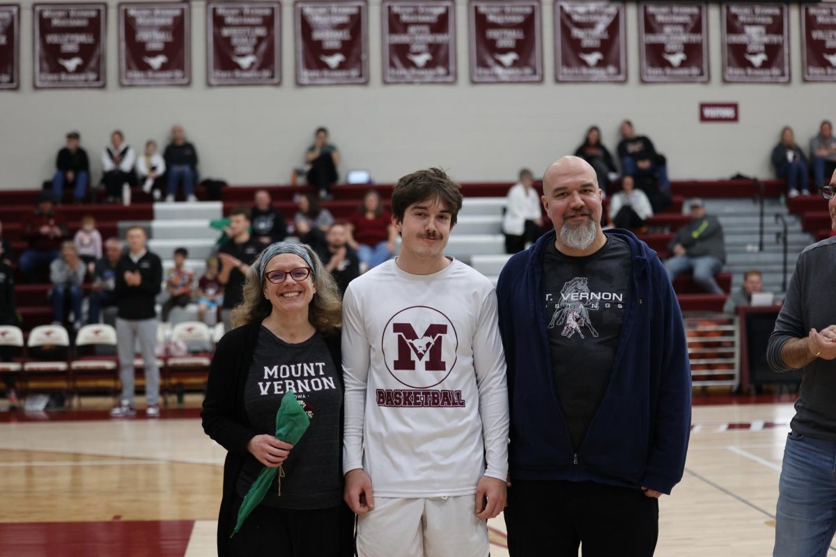 Atticus Rood with his parents on senior night. 