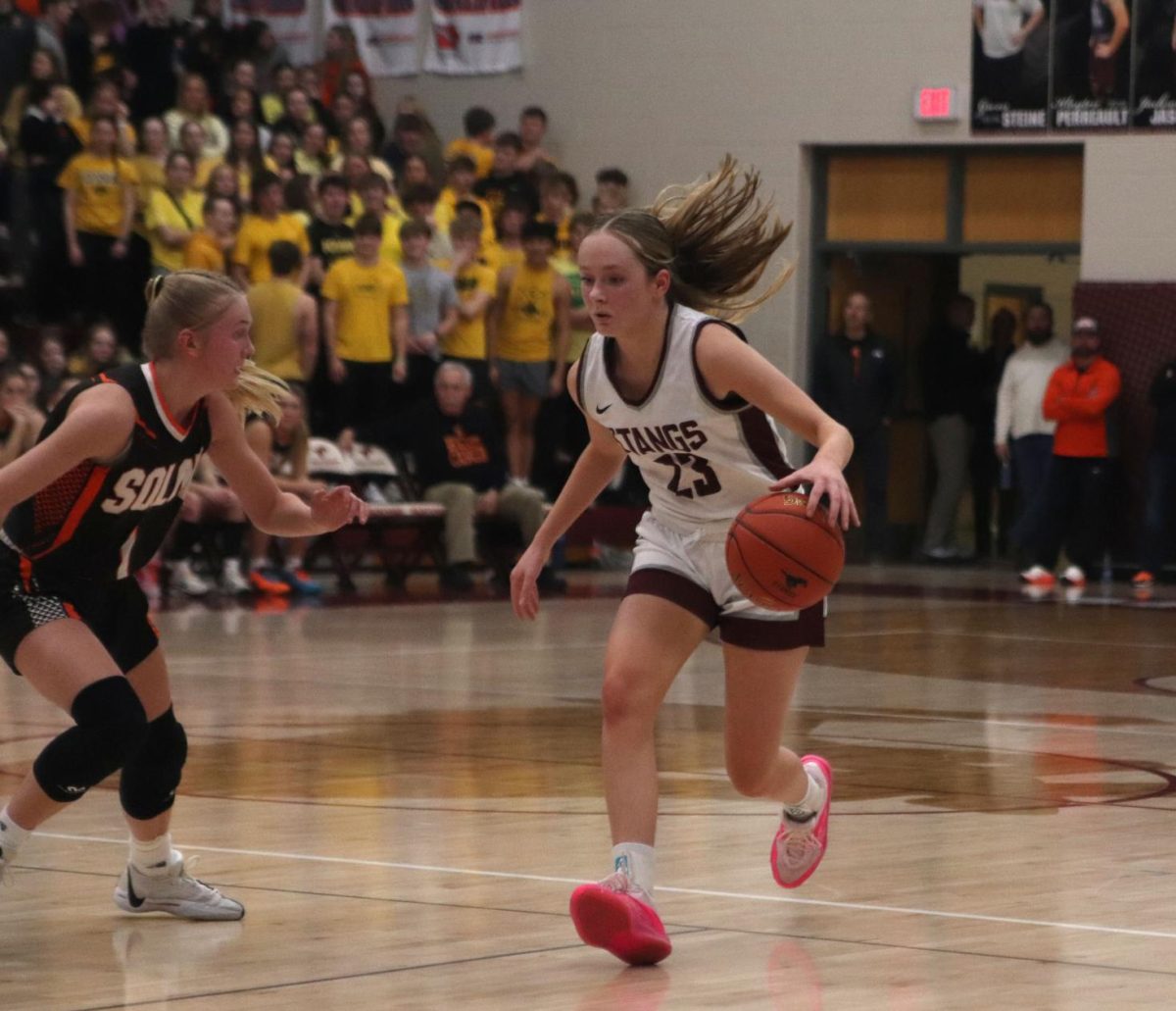 Plotting out her route, junior Sydney Huber(23) dribbles down the court. The Mustangs lost 55-54 with a last second shot from Solon on Feb. 2. 