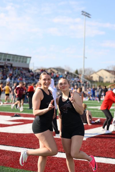 Seniors Lillian Wischmeyer and Josie Niehaus pose for a photo while warming up for their races at the home meet on Feb 28th. 
