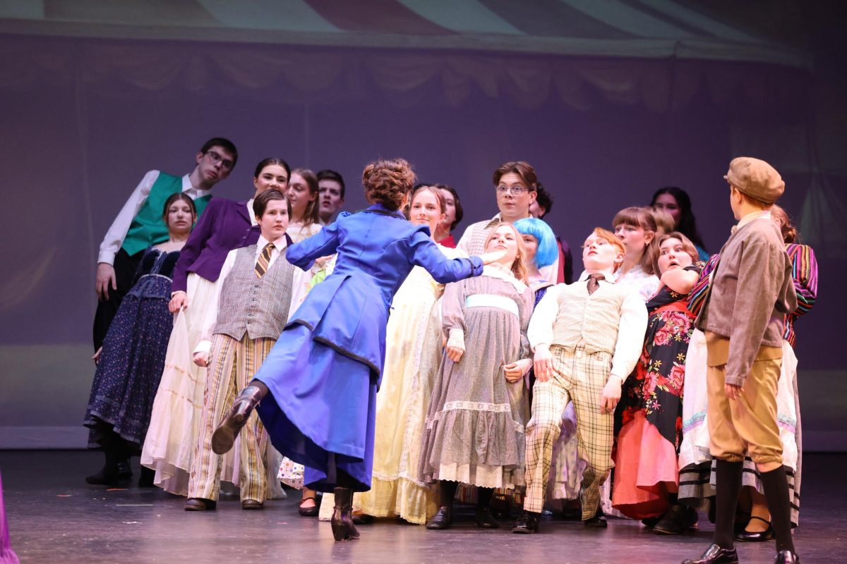 Senior Charlotte Krob (Mary Poppins) leans over the ensemble during the song Supercalifragilisticexpialidocious.  