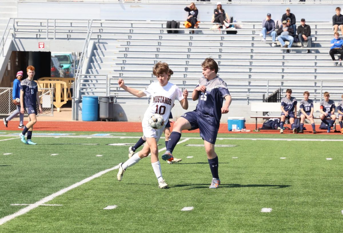 Freshman Caleb Bartelt (10) tries to keep the ball away from Shea Buenzow (25) of Xavier on April 13th. 