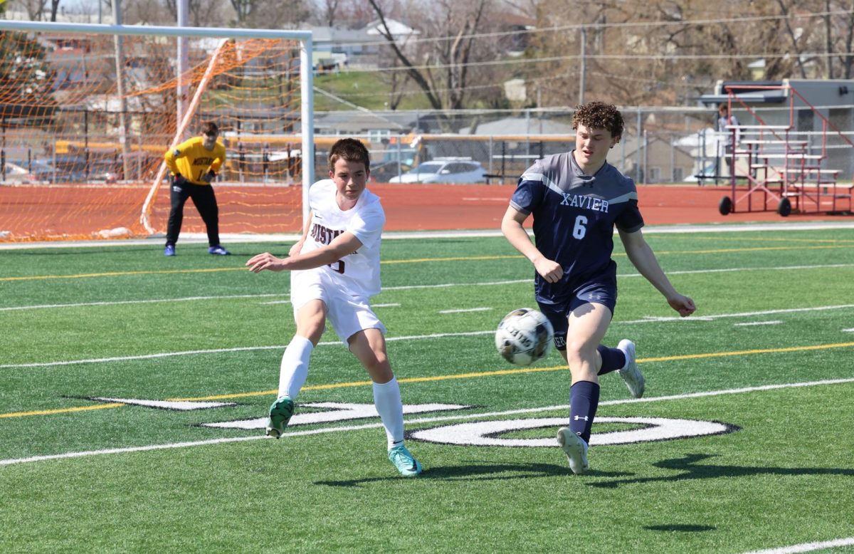 Sophomore Cash Luneckas (6) clears the ball away before Xaviers Will Forman (6) can get to it on April 13th.  