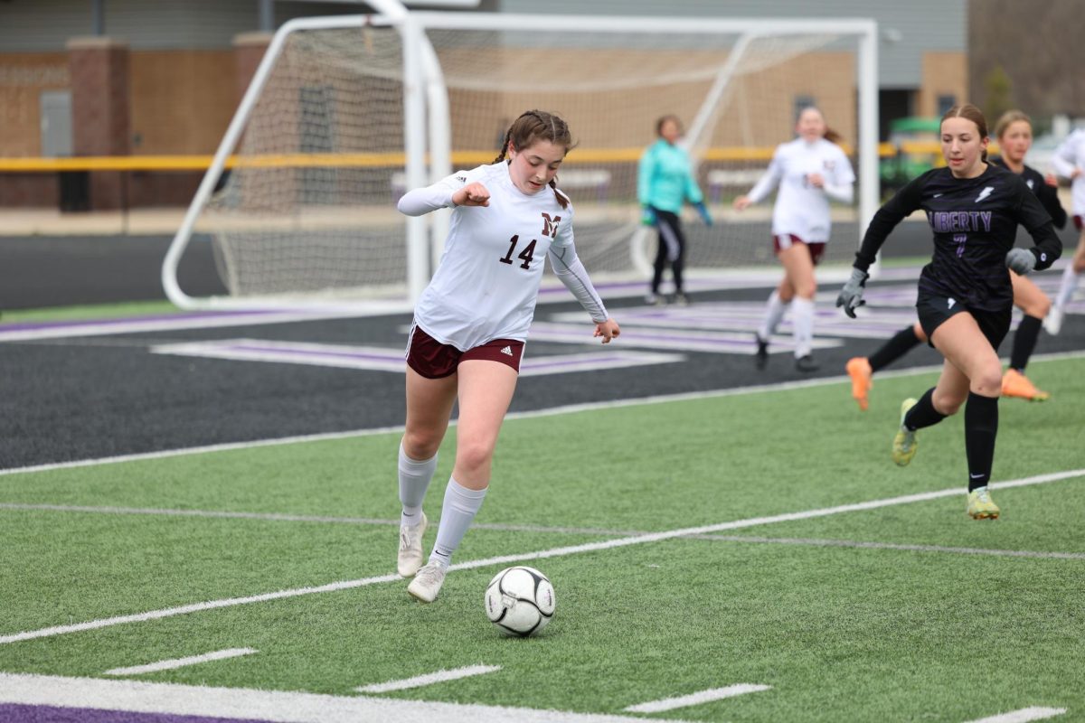 Taking the ball away from the Mustangs goal is Junior Clare Nydegger (14) as she flies past her opponent. The MVGS team lost to Iowa City Liberty 8-0 on April 4th.