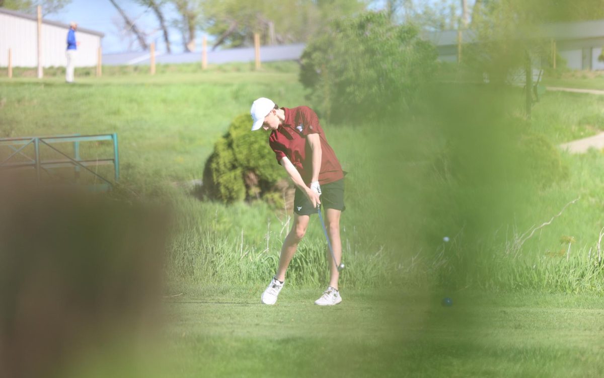 Freshman Tommy Rhomberg hits an iron off the sixth tee during the WAMAC Conference golf meet on Monday, May 6th. 