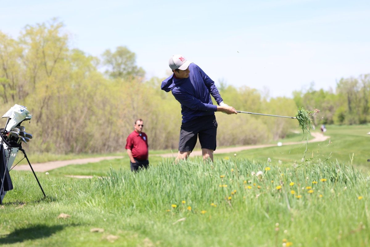 Freshman Stratton Ellyson chips his ball out of the long grass on the 18th hole at the WAMAC Conference meet on May 6th. 