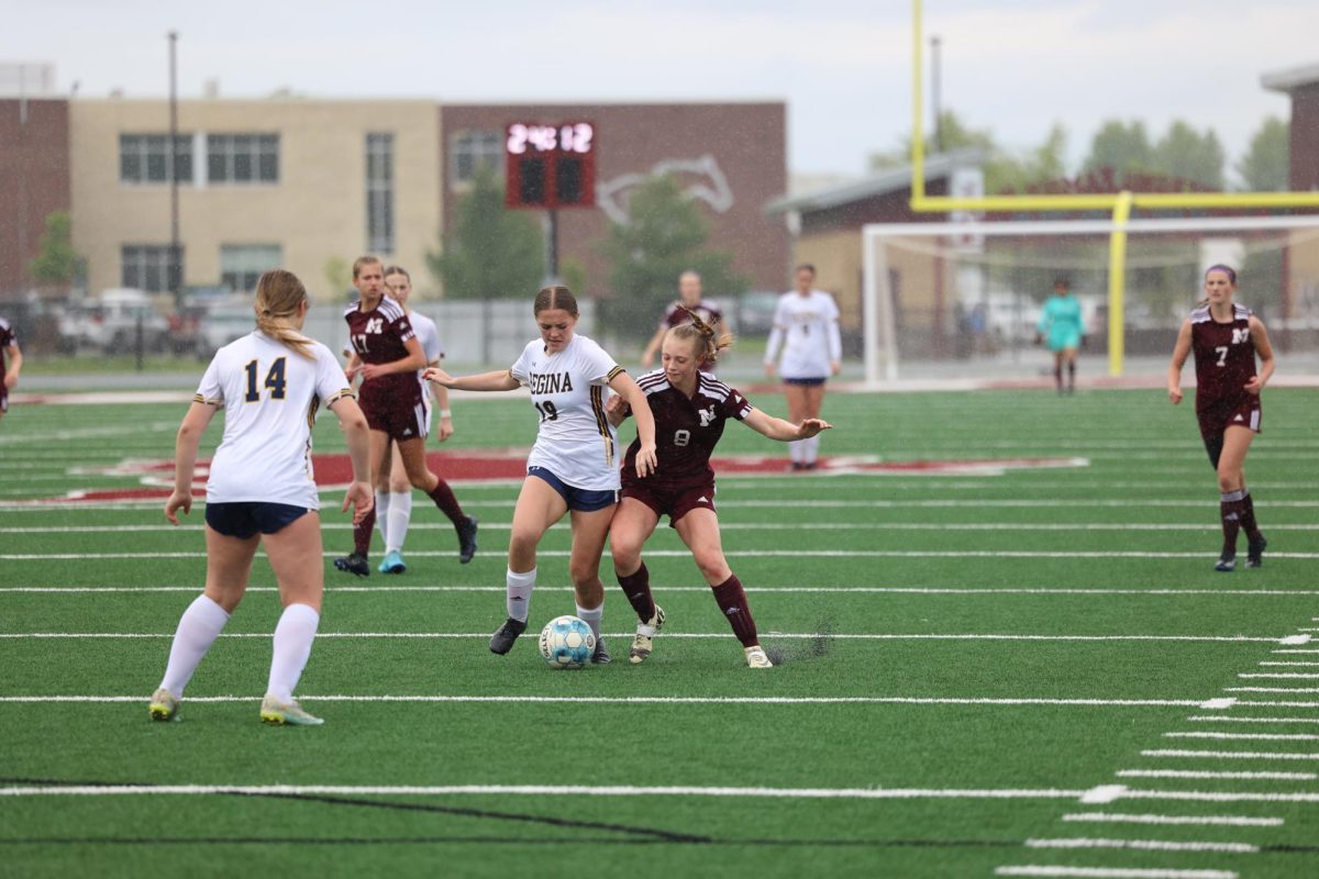 Sophomore Isabelle Logue (8) attempts to steal the ball from a Regina player on May 9th. 