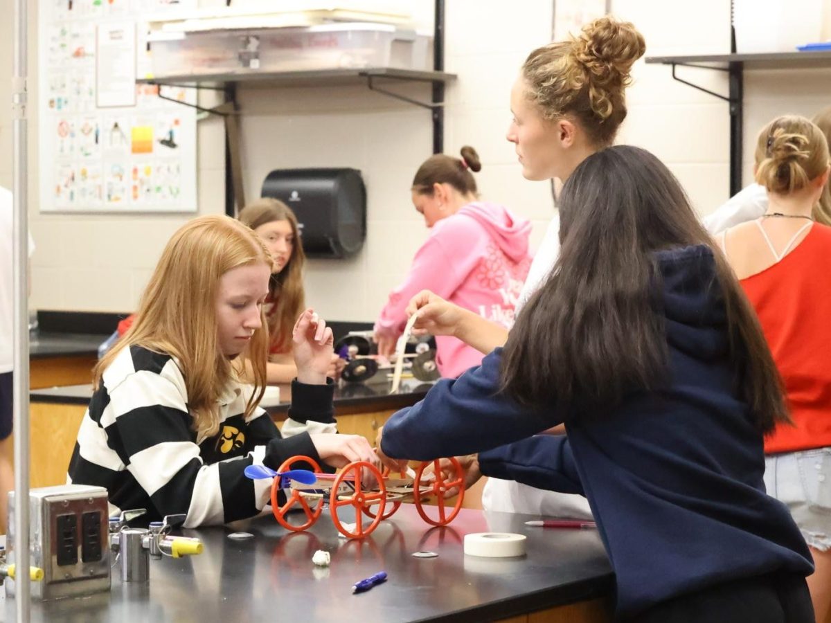 Junior Ingrid Morf works quickly to spin her rubber band on her propeller car for Physics, on Aug 30. 