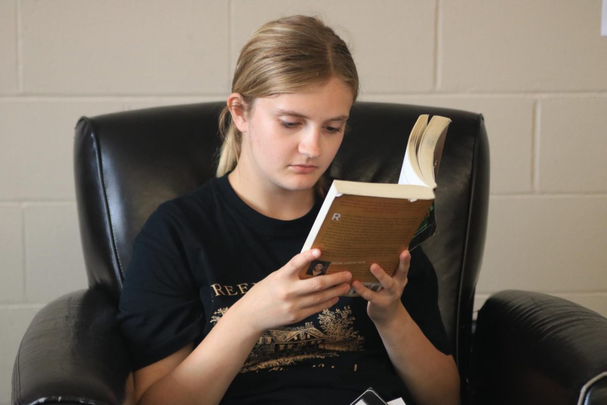 Senior Charlotte Hand relaxes in the library by reading her book during her free period Aug. 30. 