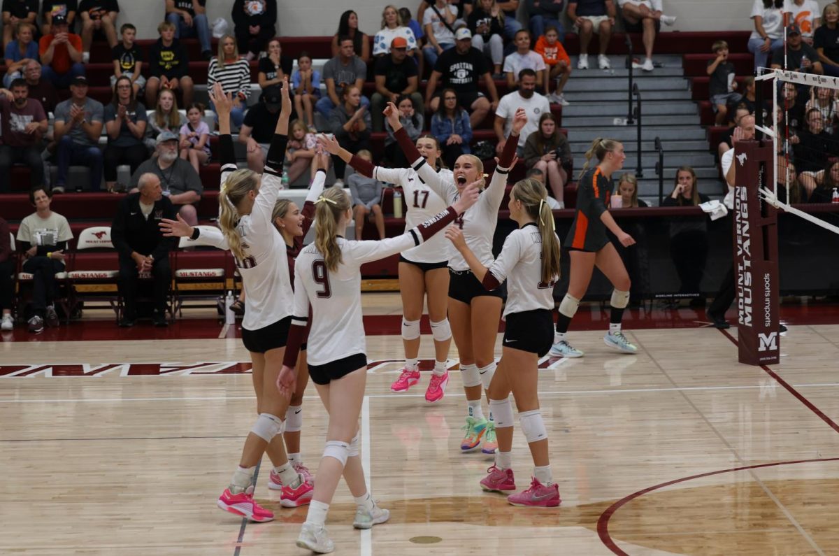 The varsity volleyball team celebrates their 3-0 win against Solon on Sept. 10. 