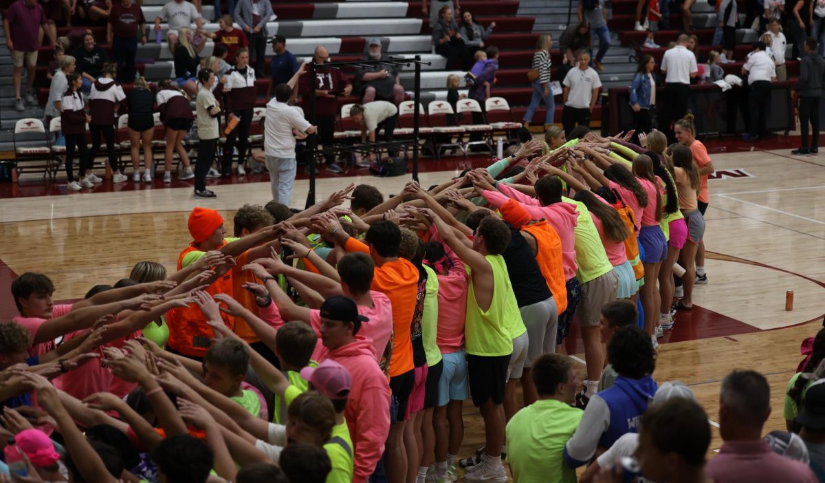 The Mount Vernon student section swarms to form a tunnel for the varsity volleyball team Sept. 10.