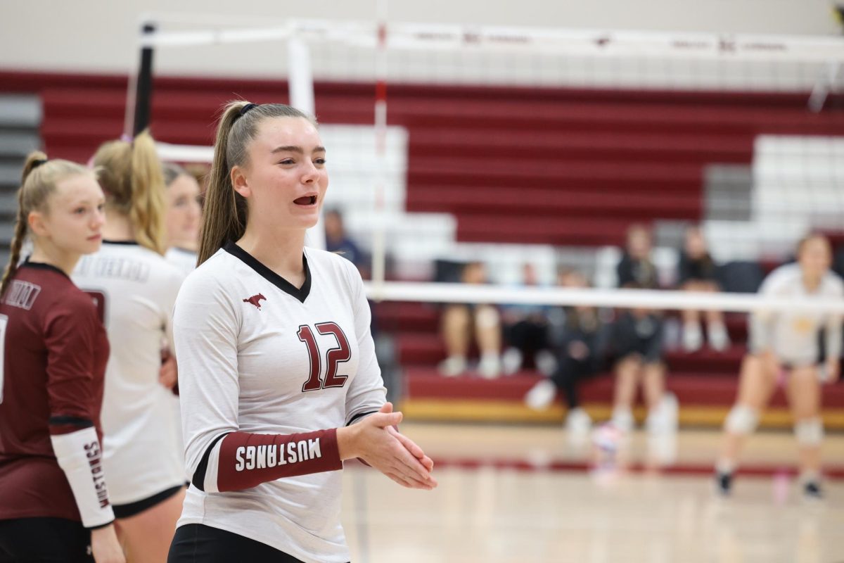 Sophomore Brynlee Bettcher (12) cheers on teammates at home game against CPU Sept. 24.