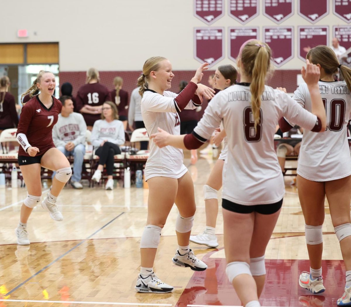 Junior Isabelle Logue (7) Celebrates 
 with her team after they score a point on Sept. 24th.