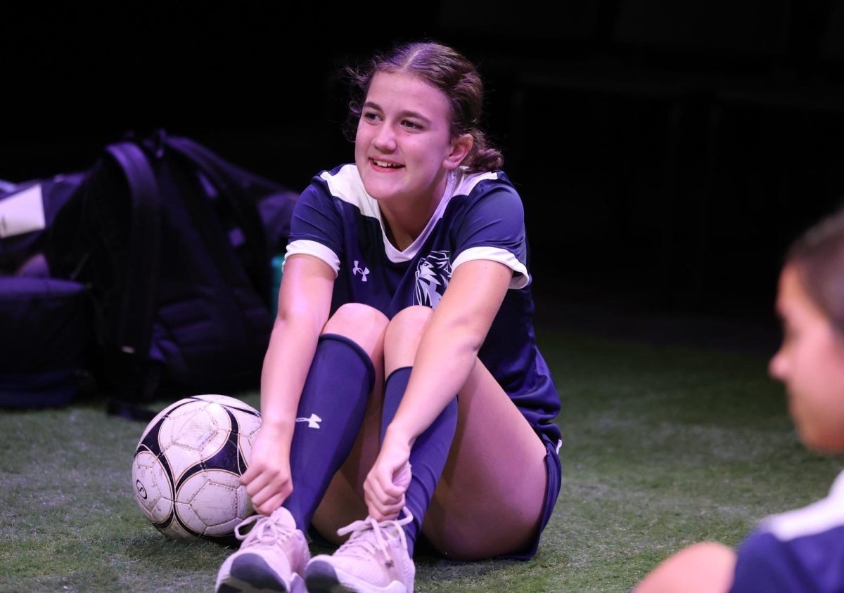 Sophomore Lyn Bauer (8) smiles at her other soccer teammates across the field. 