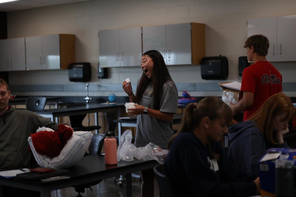 Senior Kara Swartz excitedly shows off her uncracked egg after the 2nd round of the collage physics egg drop on Sept. 5. 