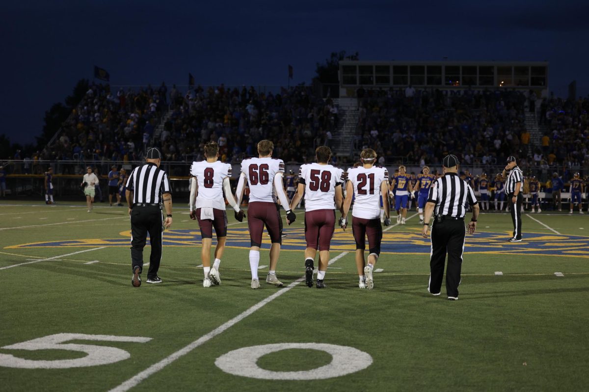 Kellen Haverback (8), Nova Lane (66), Brody Nosek (58), AJ McDormott (21) walk out for the coin toss.