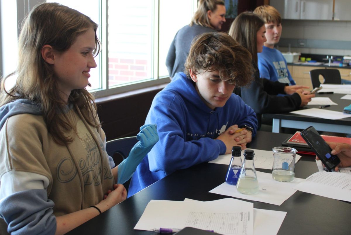 During their first lab of the year in Honors Biology, Sophomores Charlottle Woosley and Nate Poduska patiently await for their blue liquid to turn clear on Sept. 9.