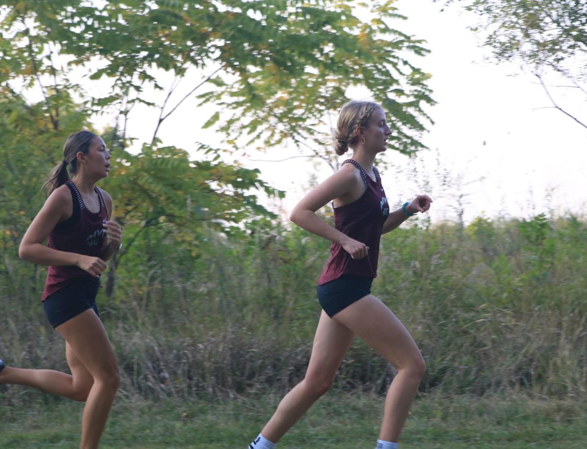 Senior Samantha Schoff and junior Claire Jenson run at the 2 mile mark in the girls varsity race at the Ames meet Sept 5.   