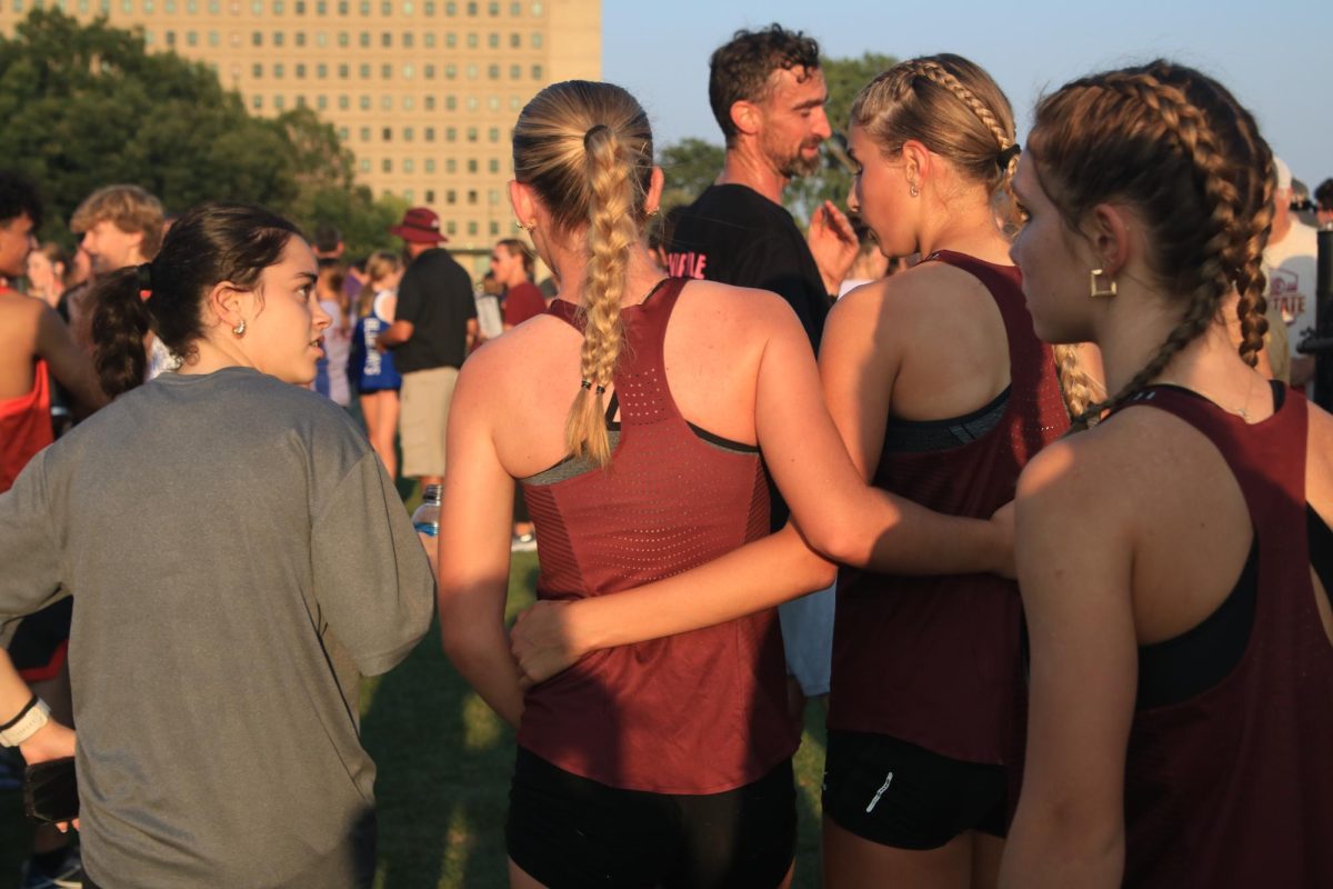 Sophomores Josie Bothell and Evelyn Moeller comfort Senior Emrie Johnson after the varsity race at the Ames meet Sept 5. 