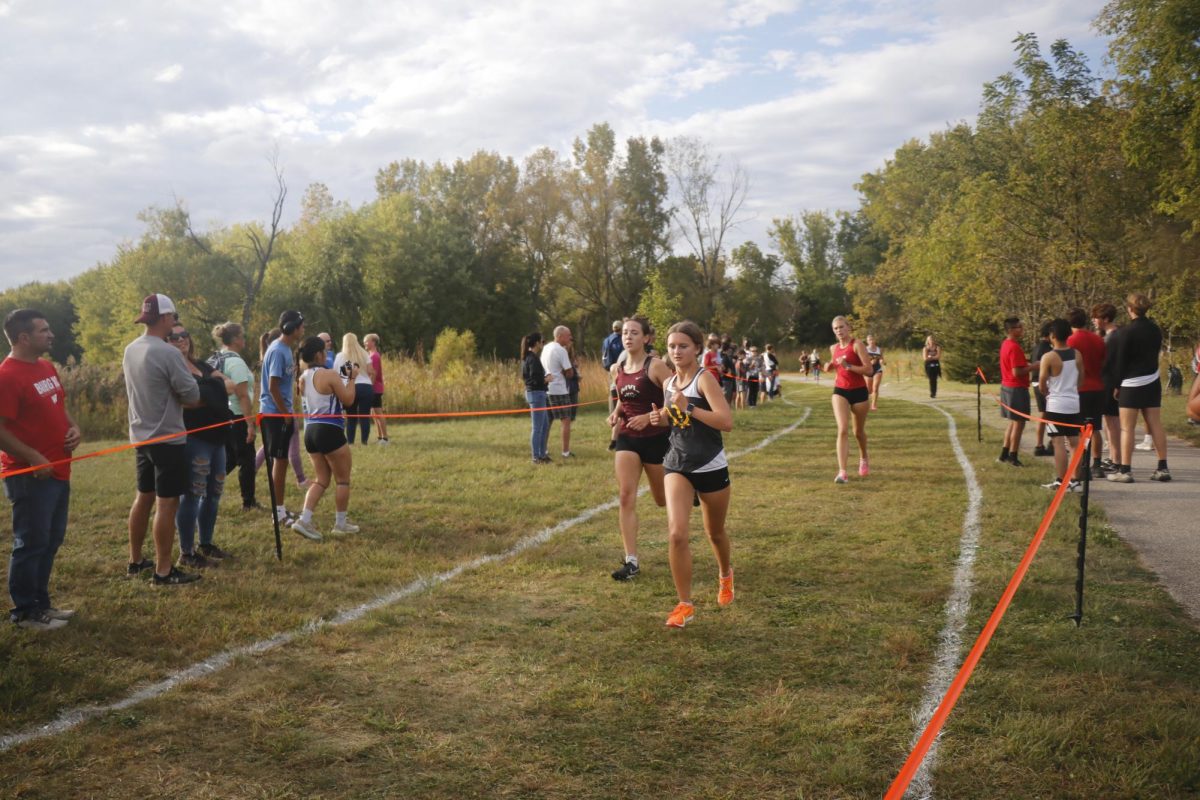 Junior Cora Smith runs with her opponent at the Solon meet on Sept 23.  