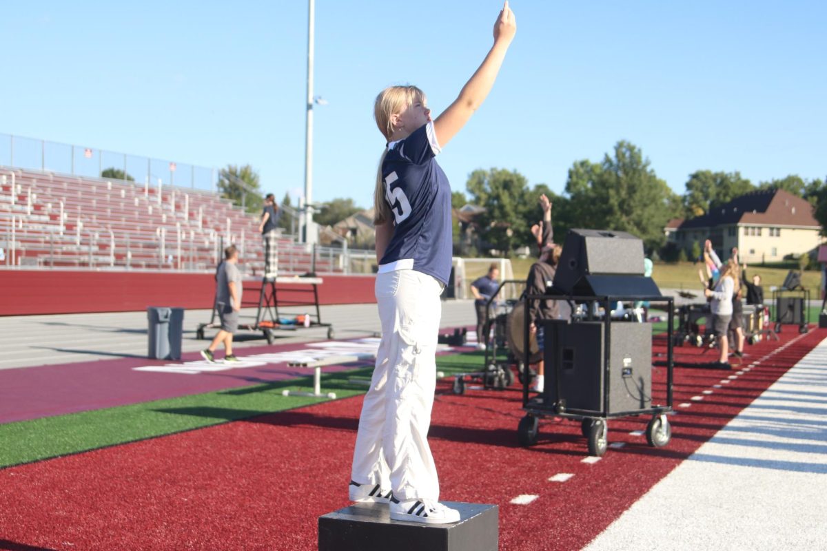 Junior Drum Major Korah Jo Robinson reaches for the stars at the end of "Among the Stars" Sept. 6. 