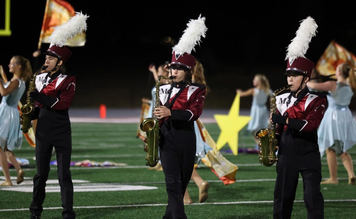 Freshman Elliot McNulty, Senior William Stevenson, and 8th grader Jake Martin march in line during the Marching Mustangs show on Sept. 6.