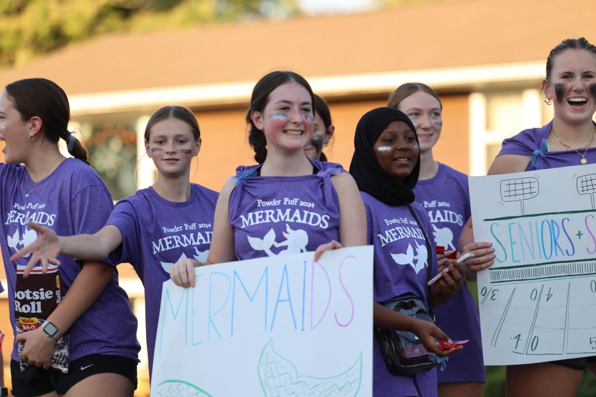 Sophomore Avery Thurn holds a powderpuff promotion sign during the MV Hoco Parade. 